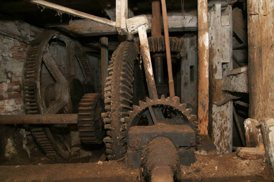 Příloha 37 Za litinovou řemenicí leţí na zemi zbytky bubnového krupníku. Vpravo je násypka kapsového výtahu. Foto Bronislav Šmatera, 2008.