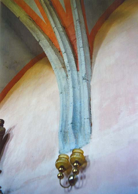 V presbyteriu kostela v Blížejově, jež se otevírá do plochostropé chrámové lodi lomeným triumfálním obloukem, opatřeným jen prostou římsou a hladkým soklem v přízemí (obr.