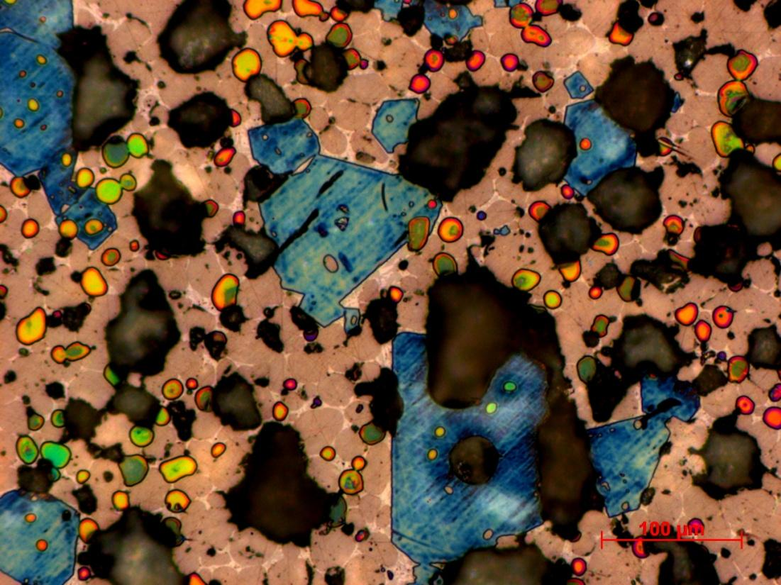 Obr. 26 Slínek 5S, modré krystaly alit, světle hnědá zrna belit, přebarvené oblasti (žlutá, oranžová, růžová, zelená) volné vápno, světlé plošky mezi zrny slínková mezerní hmota, černé difúzní