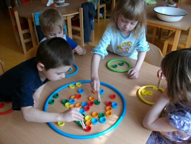 Opět byly použity k činnosti různobarevná víčka od plastových lahví. Tentokrát si děti zahrály na rybáře. Nejprve si děti vyzkoušely chytání rybiček pomocí kolíčku na suchu.