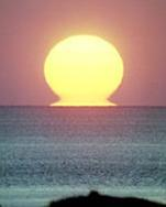Jedním z jevů, které způsobuje spodní zrcadlení, Na obrázku je dobře vidět, že u vzduchu se paprsky ohýbají vždy k hustší vrstvě. je západ slunce ve tvaru řeckého písmena omega.