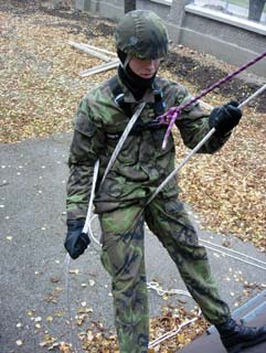 4.6.3 Slaňování s materiálem Ve výcviku SÚ PČR je případný materiál zpravidla zavěšen pomocí karabin nebo smyček na taktické vestě bojovníka - lezce.