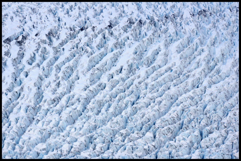 Ledovec Zajímavý pohled na ledovec se naskytl z letadla. Je poset mnoha trhlinami, ale také spoustou tyrkysově modrých ledovcových jezírek.
