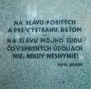stene je umiestnená pamätná tabuľa z čierneho kameňa.