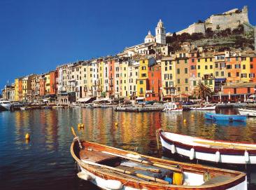 Ligurská riviéra a vesnice Cinque Terre LIGURSKÁ RIVÉRA A VESNICE CINQUE TERRE S KOUPÁNÍM Skalnaté pobřeží Ligurie a za ním kopce pokryté vinicemi.