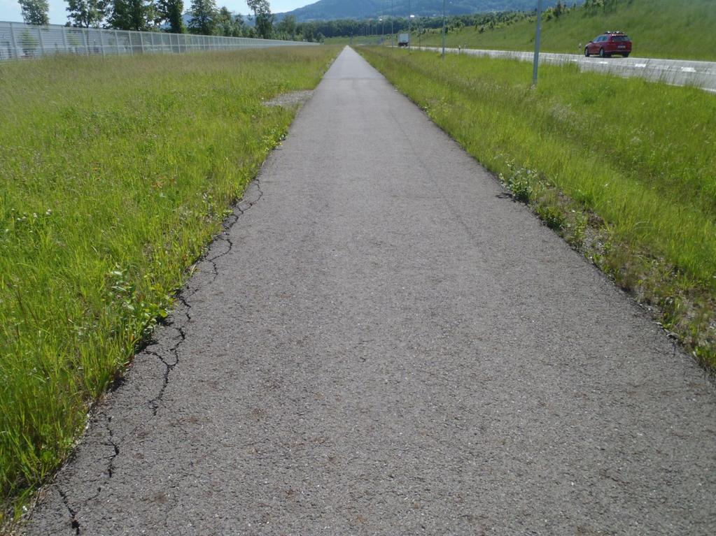 Obrázek 21: Olamování okrajů vozovky - Puchýře v litém asfaltu (MA mastix asphalt) Vyvýšenina ve tvaru puchýře o průměru 5-25 cm v obrusné vrstvě z litého asfaltu na betonovém nebo