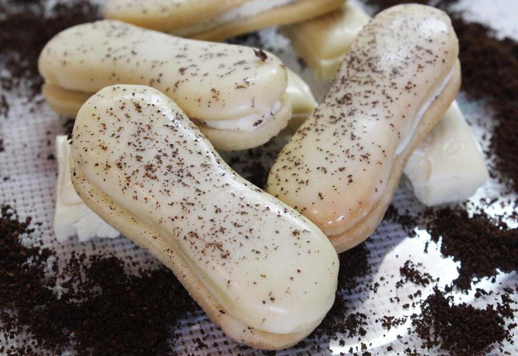 Kávové piškotky Ingredience 200 g hladké mouky, 80 g moučkového cukru, 140 g tuku nebo másla, 1 žloutek většího vejce Dokončení kávový krém, bílá čokoládová poleva, mletá káva Postup Ze všech surovin