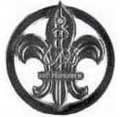 kovového odznaku umístěna heraldická lilie s kotvou a částí lana, na spojovací pásce heslo Buď připraven; povrch v barvě stříbrné; upínání: šroub s matičkou