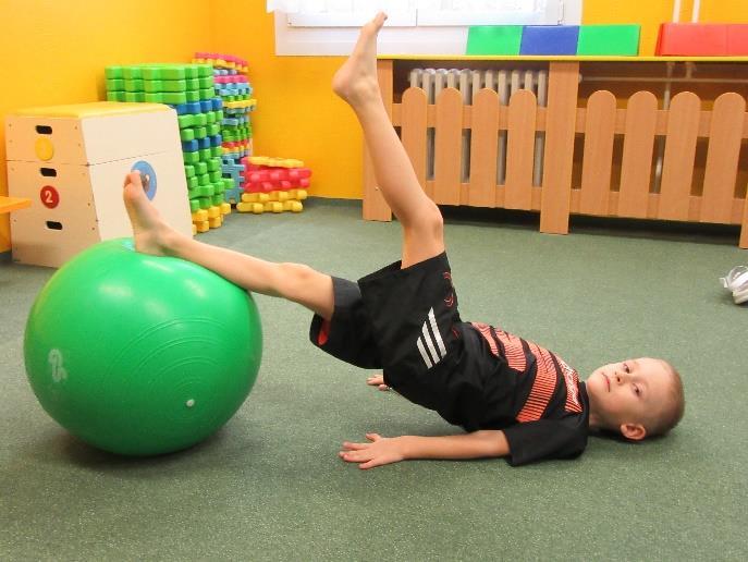 CVIČENÍ NA VELKÉM MÍČI 9.5.2 STŘÍHÁNÍ Zaměření: Stabilizace páteře, pánve a dolních končetin. Výchozí poloha: Lehneme si na záda, horní končetiny opřeme o zem. Dolní končetiny položíme na míč.