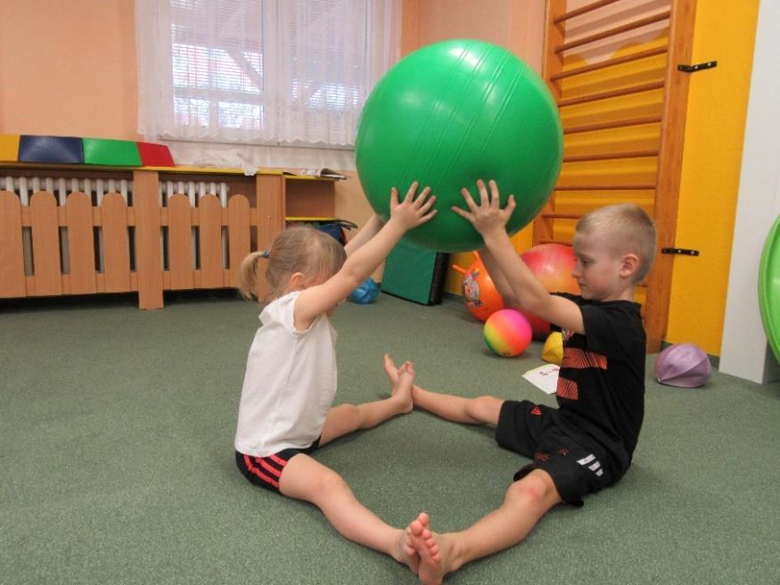 CVIČENÍ NA VELKÉM MÍČI 9.7.2 POMOCNÍČCI Zaměření: Protažení svalů horních končetin, zádových svalů a svalů zadních, vnitřních stran stehen (m. biceps et triceps brachii, m. erectror trunci, mm.