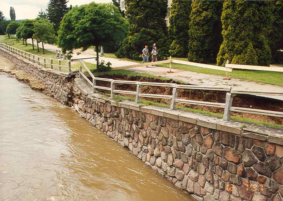 Kaverna za poničenou opěrnou zdí u mostu