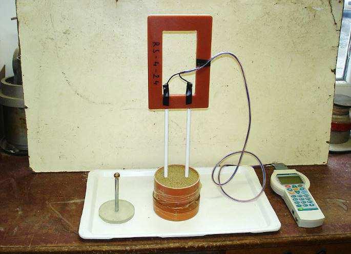 Obr. 1 Měření frekvenční analýzy dvojicí elektrod uspořádaných do tvaru vidličky napojených na Z-meter III po nasypání písku do zkušebního válce a zhutnění statickým tlakem Pro řešení uvedené úlohy