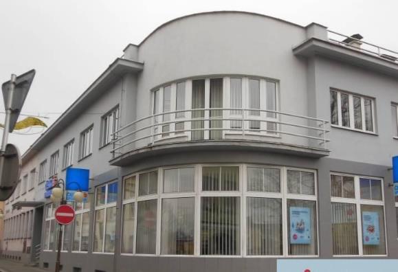 Jednoduchý obdélníkový tvar dvojpodlažních domu s valbovou střechou oživují O. Poříska, Kino, Frenštát/R. vystouplé kamenné vstupní Oskar Poříska, budova Spořitelny, Frenštát/R. rizality.