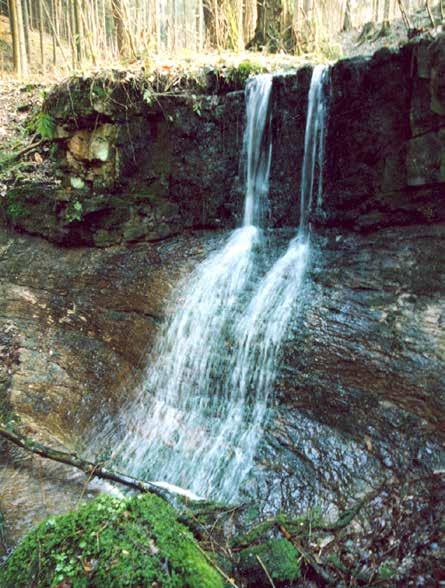 Foto 5: Nejvýše položený vodopád Náchodeckého potoka s dobře patrným kontaktem lavice kvádrových cenomanských pískovců (horní svislá část) s triasovými pískovci (ve spodní části stěny) (k článku na