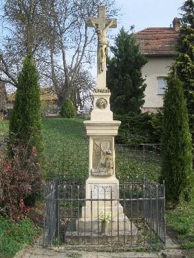 Na vrcholu postava klečícího vojáka, u paty památníku je socha klečící ženy s
