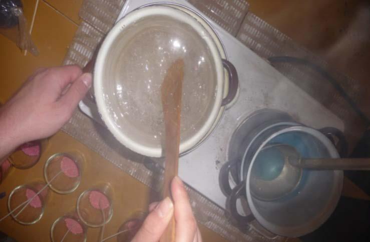Barvy gelu, které jsme používali, byly žluté, růžové, modré, červené a oranžové. 2) Mezitím jsme si nachystali skleničky, do kterých se připevnil knotek a ten se zasypal barevnými kamínky.