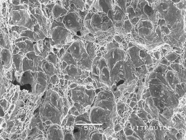 Obr. 7 Příklad jamkového tvárného porušení, REM zobrazení v sekundárních elektronech 5. Křehký lom Z makroskopického hlediska je křehký lom protikladem tvárného lomu.