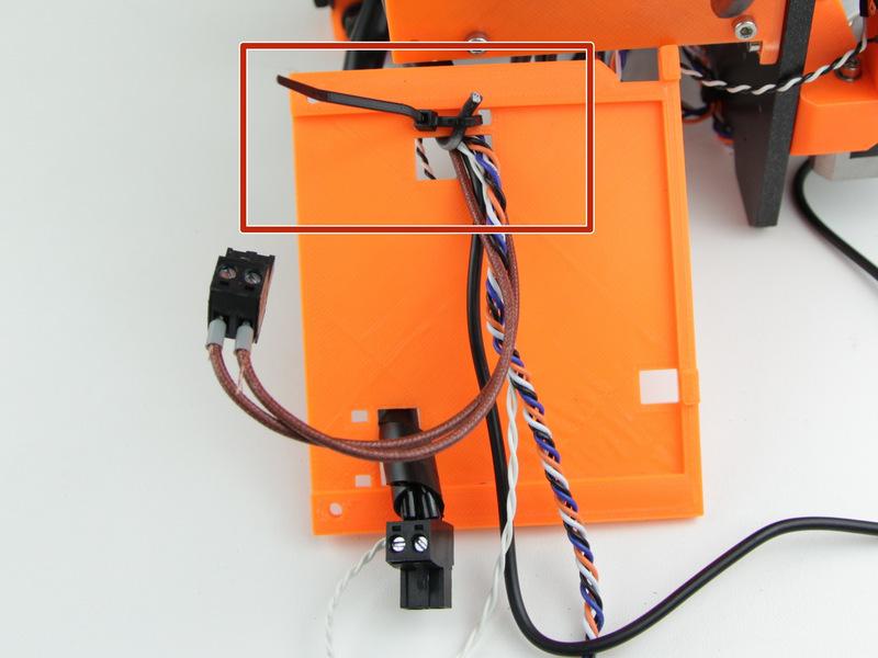 Step 11 Uchycení kabelů Podle obrázku uchyťte kabely od extruderu ke krytu elektroniky stahovacími páskami.