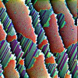 Areas with different distances of the monoatomic stripes are visible.