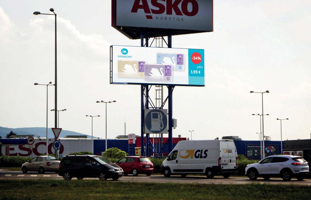 LED obrazovka s dlhým priamym nájazdom na kruhový objazd, smerom na nákupné centrá. Belá 6469, Trenčín na pylóne HM TESCO Trenčín, GPS 48º51 52.49 18º01 17.