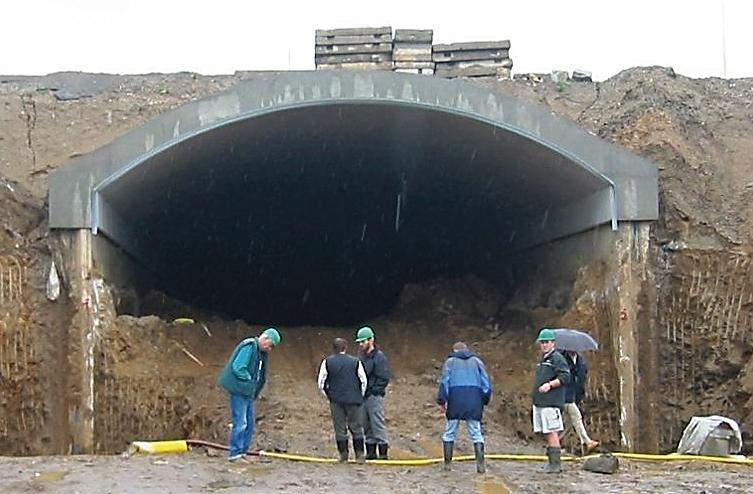 Obr. 26-17: Jihlavský tunel při čelním odtěžování Možnou variantou tohoto klasického postupu je vytvoření klenbové betonové konstrukce přímo na vytvarovaný terén, který vytvoří přímý podklad pro