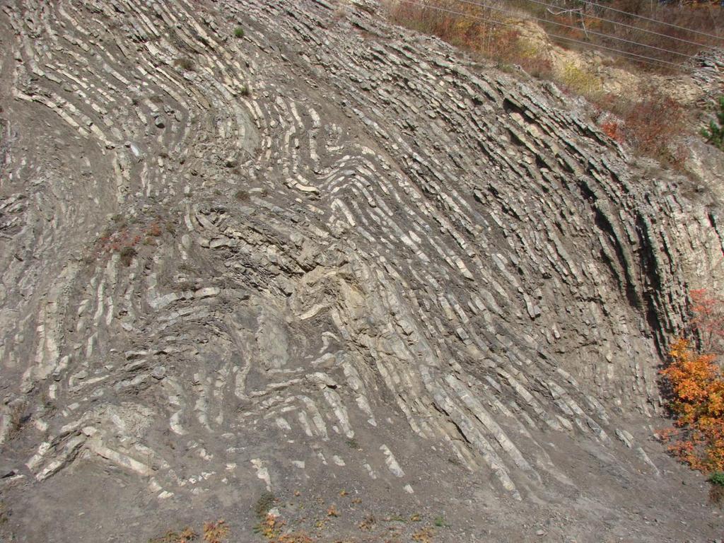 nejspíš o šikmé vrásy se slabou jv. vergencí. Abychom zjistili skutečné parametry zdejších vrás, je nutné sestrojit geologické řezy kolmé ke směru vrásových os.