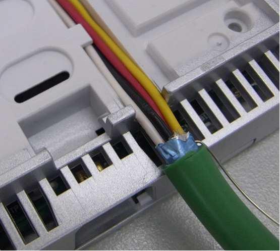 Montáž na stěnu Než vložíte kabel do drážky, odstraňte zarážku.