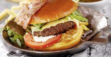 grilovaný hovězí burger v brioškové housce s plátkem goudy, restovanou slaninou, cibulí, rajčetem a rukolou, podávaný s barbecue omáčkou a hranolky Burger XXXLutz Style