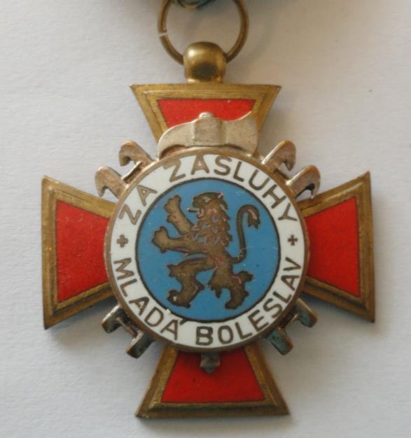 Na střed medaile je položen kruhový medailon, který je podložen zkříženými hasičskými hákovými žebříky a kolmo postavenou hasičskou sekyrkou (bourací sekyra), jejichž horní části (u žebříků zakončení
