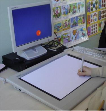 Obrázek 4: Obrázek ukazuje cíl (červený kruh) a kurzor (žlutá tečka), které jsou viditelné na obrazovce. Digitální tablet, který má na povrchu list papíru je umístěn před obrazovkou (Ferguson et al.