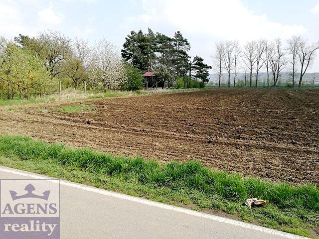 mezi ul. K Lázním, z níž je na pozemky vjezd, a řekou Berounka. Oba leží v záplavovém území.