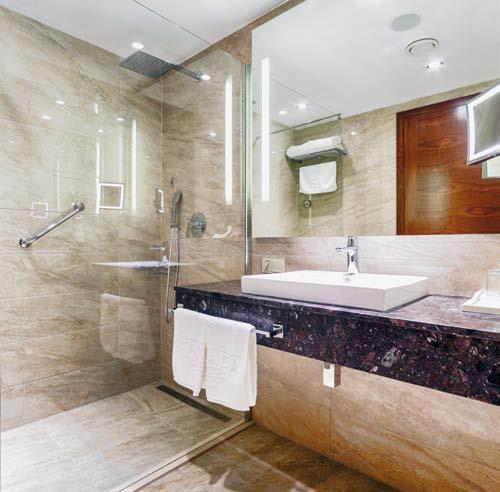 Sprchy v úrovni podlah z přírodního kamene, dodaly pokojům kompaktně harmonic ký a vzdušnější vzhled. TECEdrainline nabízí také výhody ve smyslu provozních nákladů.