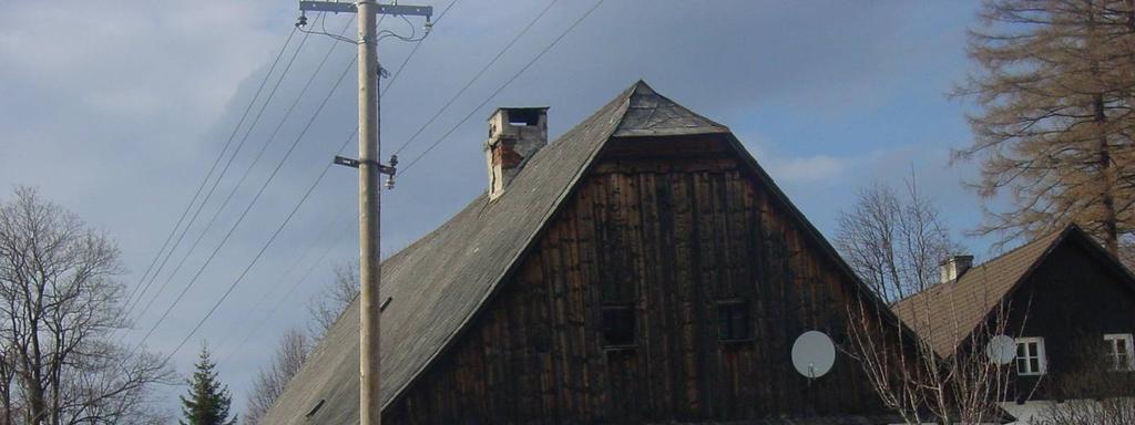 Štít tradičního jesenického domu s polovalbou ve vrcholu (Malá Morávka) Původně sloužila roubená část jako obytná a ve zděné části byla maštal, stodola a hospodářské zázemí Svébytnou tradiční