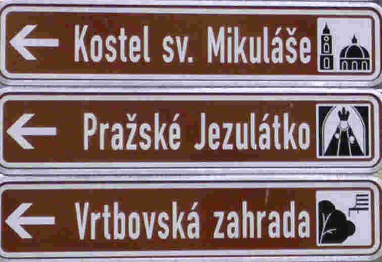 IS 24a má základní tvar obdelníku (nemá tvar šipky), na které je znázorněno: Název cíle, Příslušný piktogram, Příslušný šipkový