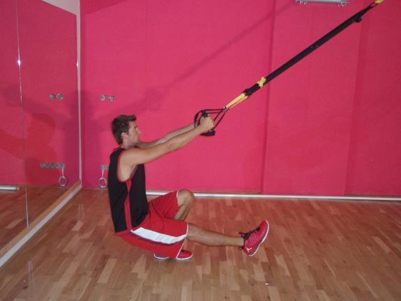Dřep na jedné noze s přednožením Obrázek č: 4a, Zdroj: (autor 2013) Obrázek č: 4b, Zdroj: (autor 213) Základní poloha: mírný podřep na levé noze, přednožit pravou, předpažit, uchopit TRX dlaněmi k
