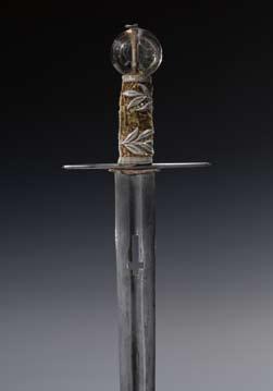 Svatováclavský meč (korunovační meč) Železo, dřevo, záhněda, hedvábné lampasy a samet, stříbrné nitě; délka 93,5 cm, z toho čepel 76 cm. Štíhlá železná čepel s širokým středním žlábkem (10.