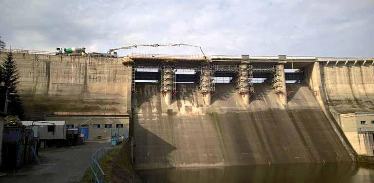 STAVEBNÍ KONSTRUKCE STRUCTURES 6a Obr. 6a,b Pohled na vzdušnou stranu hráze v průběhu betonáže Fig. 6a,b View to the airy side of the dam during the concreting 6b cca 100 mm.