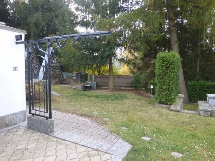 Níže od betonového koryta za nižší opěrnou stěnou kamenného zátiší je také zvýšený sokl pro umístění běžně prodávaného většího umělohmotného kompostéru.
