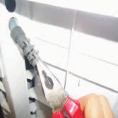 Šedá hadice se připojuje k přemostění na levé straně spotřebiče.