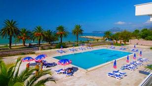 Hotel leží 30 m od pláže, od níž je oddělen pouze promenádou. Hotel je obklopen středomořskou vegetací a krásnou zahradou.