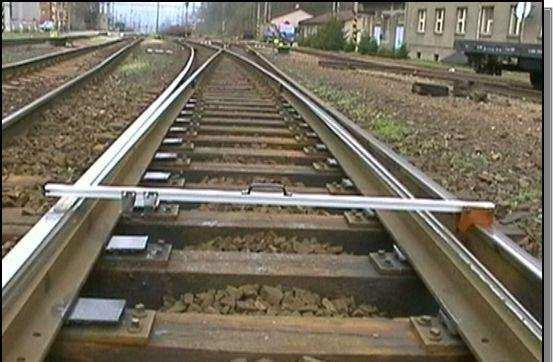 trajektorie přechodu kola vozidla z křídlové kolejnice na hrot srdcovky a opačně rovinatost broušených ploch.