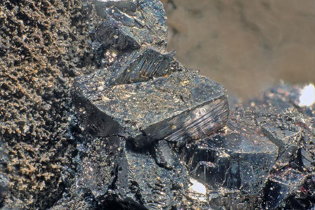 Obr. 26 Krystaly miargyritu narůstající na Sb bohatý arsen z okolí 7. patra. Ze vzorku byl chemicky odstraněn kalcit. Foto P. Škácha. Šířka záběru 4 mm. rozmezí poměru 0.93-1.95.