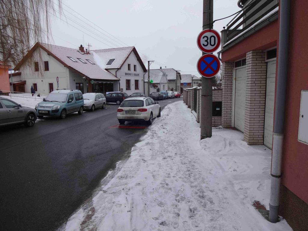 Přechod pro chodce mezi hostincem a dětským hřištěm je označen dostatečně jak svislým, tak vodorovným značením.