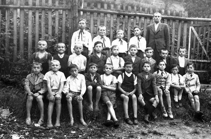 Na pár věcí bychom mohli přijít při pečlivějším, druhém pohledu sami, některé ale potřebují výklad pamětníka. Tím pamětníkem je pan Bořivoj Nejezchleb, chlapec stojící hned vedle učitele.