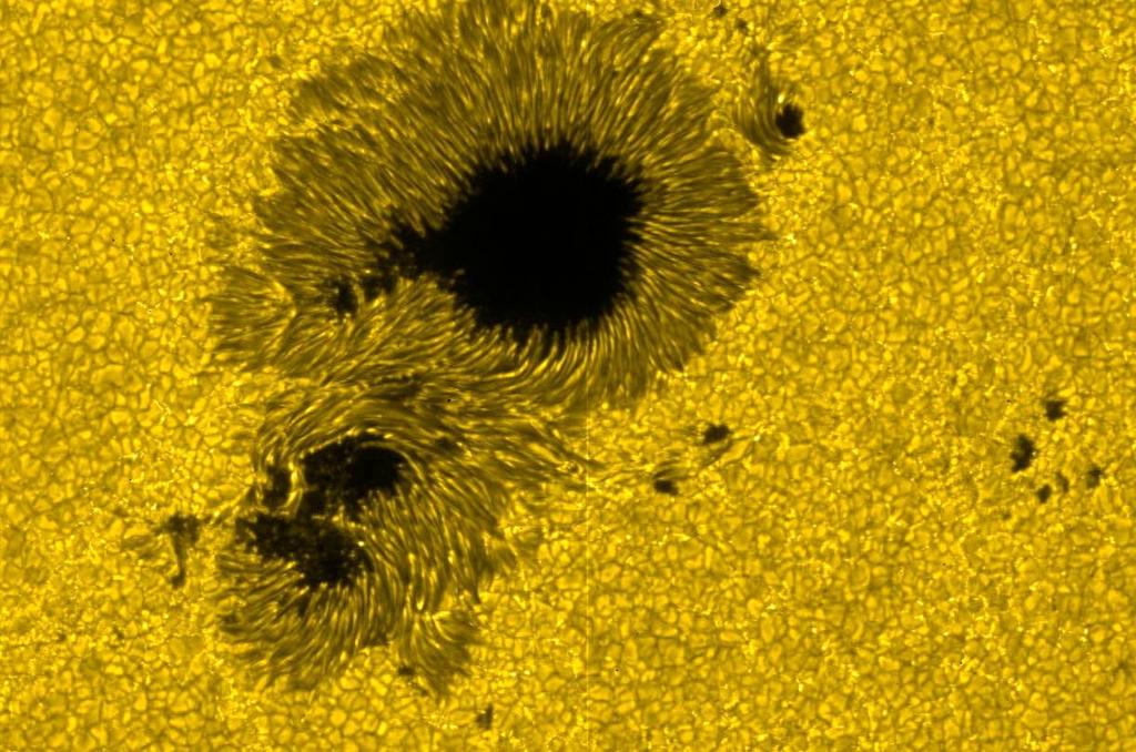 Sluneční skvrny dočasné útvary ve fotosféře odpovídají chladnějším oblastem teploty ~3000-4500 K, okolí ~5780 K velikosti od ~16 do ~160 000 km doba života dny až týdny vznikají