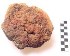 a vrchní strana s otisky prstů; b spodní strana s patrným ostřivem těsta. Foto G. Hekelová. hrobových jam byly identifikovány pouze podle inventáře sestávajícího z torz keramických nádob (obr.