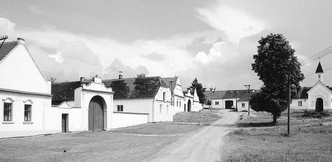 BUDIČOVICE A SKÁLY Budiãovice panorama návsi od severozápadu (2002) vodu, jak nasvûdãují detaily fasády se tukov mi motivy boïího oka nad okny. Uprostfied návsi stojí v klenková kapliãka se zvoniãkou.