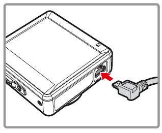 Připojte jeden konec napájecího adapteru k portu napájecího konektoru na videokameře.