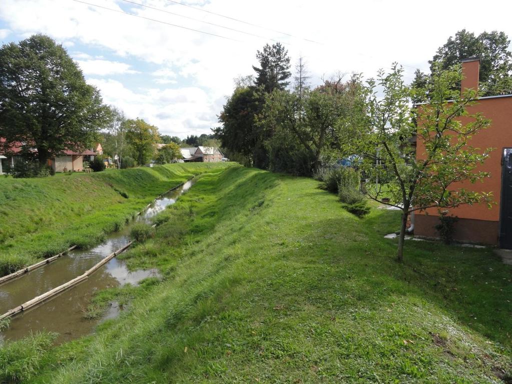 Voblasti ř.km 2,400 protéká Luha v těsné blízkosti obytných domů (Obr. 6.