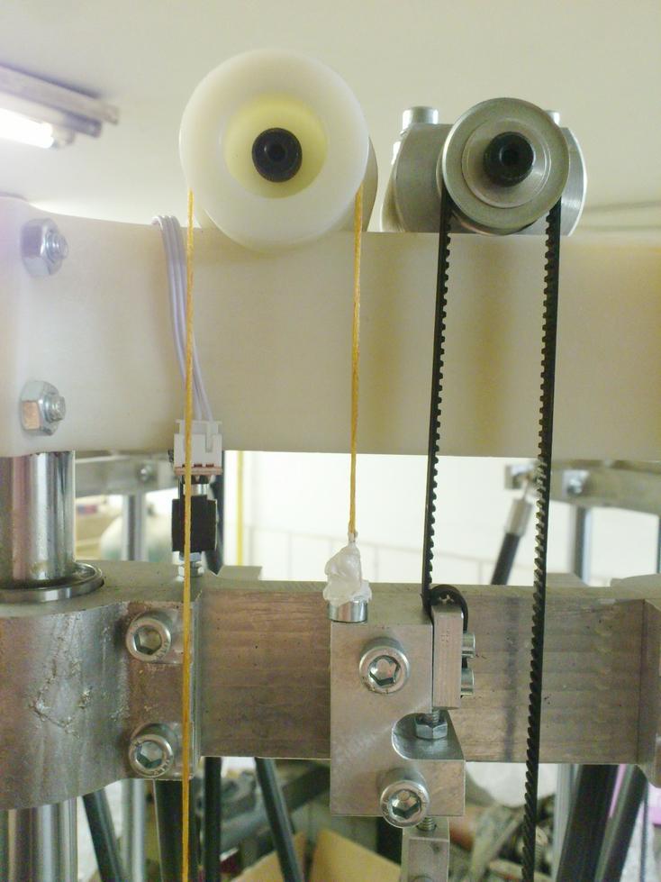 Obrázek 5.1: Princip vyvážení vertikálně posuvných vozíků. Závaží zavěšené na druhém konci oranžového lanka se pohybuje ve vodicí trubce.